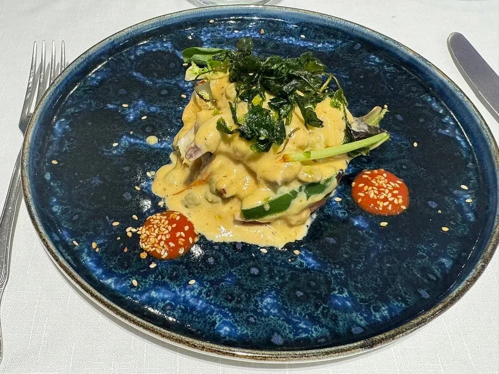 Plato de temporada con salsa cremosa, verduras crujientes y sésamo