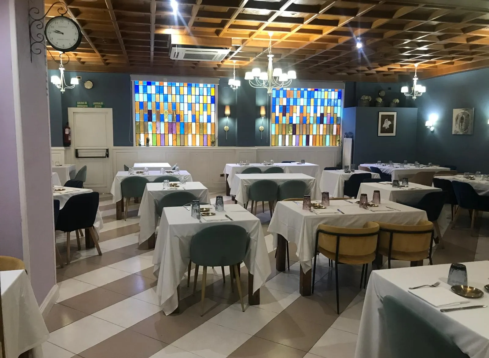 El comedor de Kukutze, con sus vidrieras de colores y las mesas vestidas